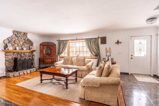 living room with ornamental molding, a stone fireplace, and dark hardwood / wood-style floors