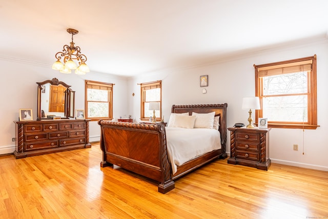 bedroom featuring ornamental molding, a chandelier, and light hardwood / wood-style floors