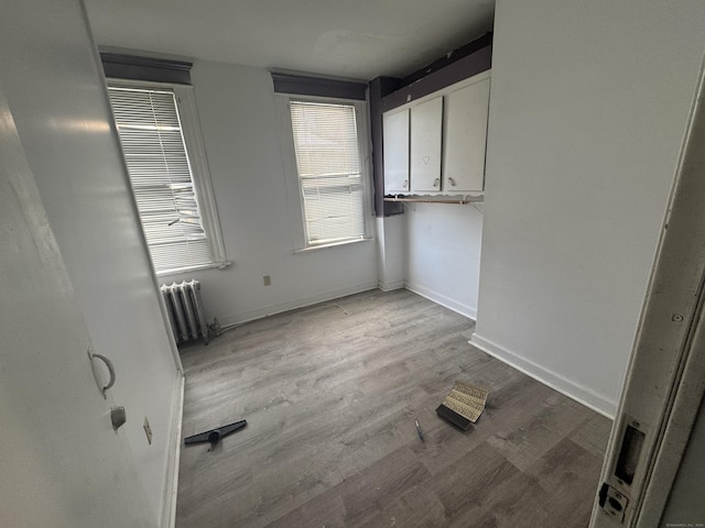 interior space featuring light wood-style floors, baseboards, and radiator heating unit