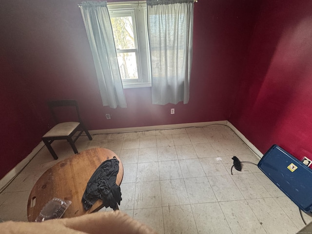 empty room with baseboards and light tile patterned floors