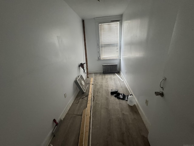 interior space featuring dark wood-style flooring, radiator heating unit, and baseboards