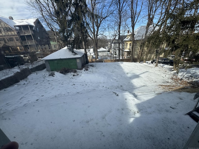 yard covered in snow with a detached garage and fence