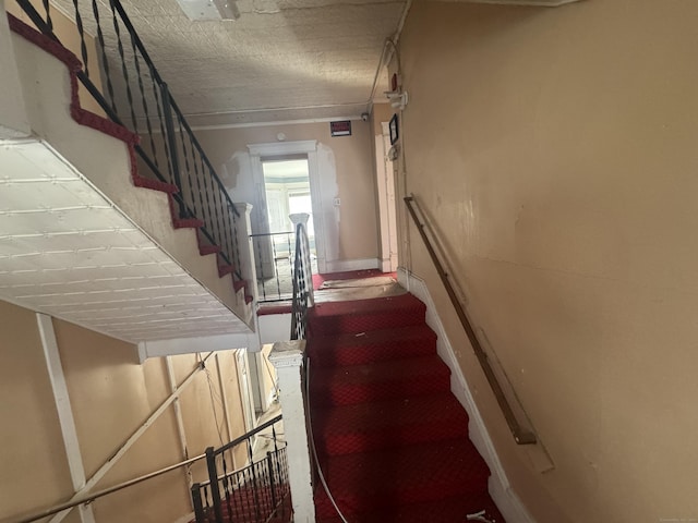 staircase featuring a textured ceiling