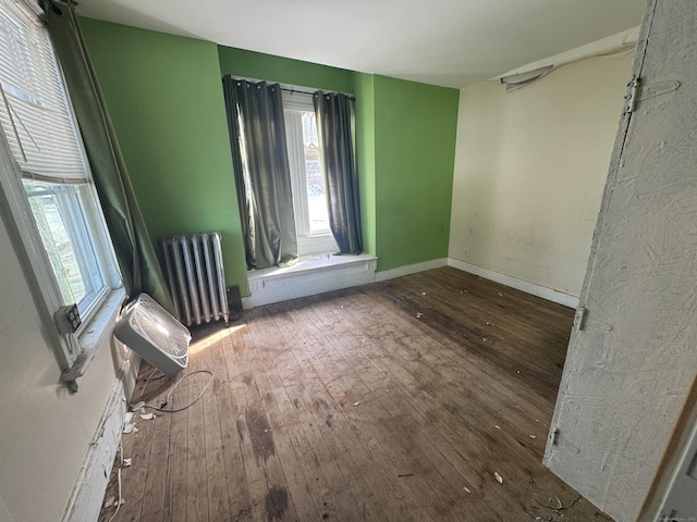 spare room with radiator, dark wood-style floors, and baseboards