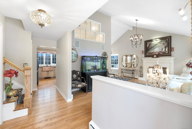 interior space with beamed ceiling, high vaulted ceiling, a notable chandelier, and light hardwood / wood-style floors