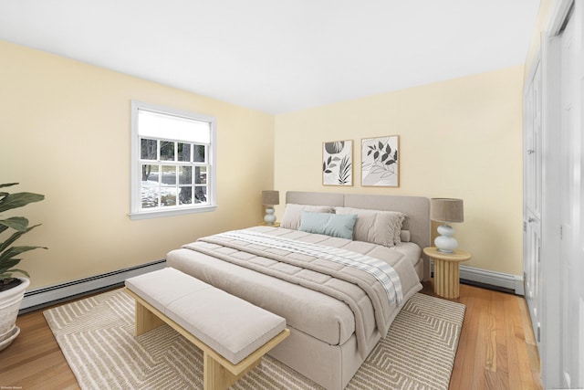 bedroom with light hardwood / wood-style floors and baseboard heating