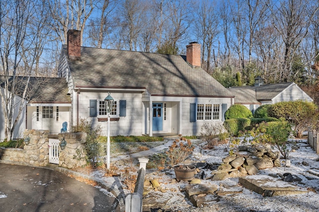 new england style home featuring a chimney