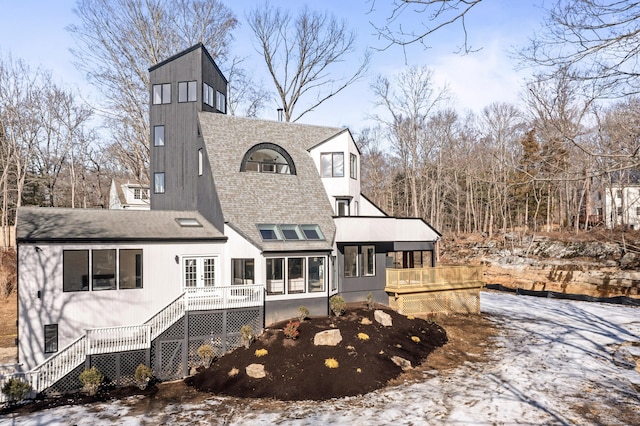 snow covered house featuring a deck