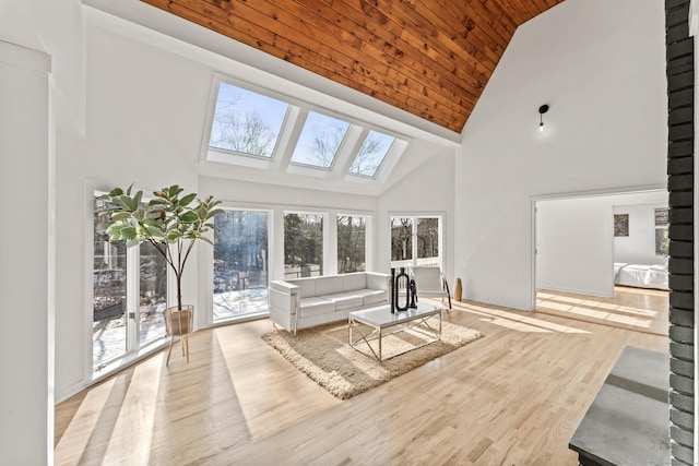 unfurnished living room with a skylight, wooden ceiling, high vaulted ceiling, and light hardwood / wood-style flooring