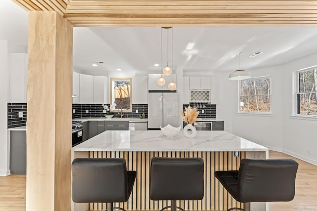 kitchen featuring hanging light fixtures, appliances with stainless steel finishes, a center island, and white cabinets