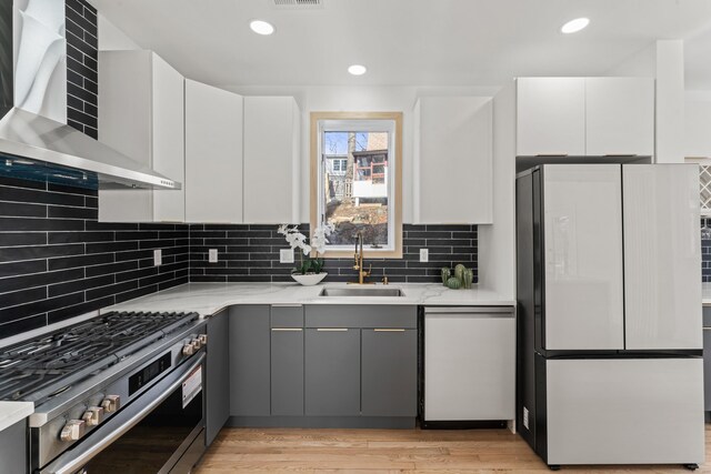 765 Durham Rd, Guilford, CT 06437 - kitchen featuring wall chimney exhaust hood, white dishwasher, a sink, freestanding refrigerator, and gas stove
