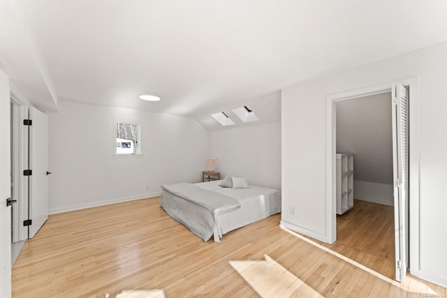 bedroom featuring lofted ceiling and light hardwood / wood-style flooring