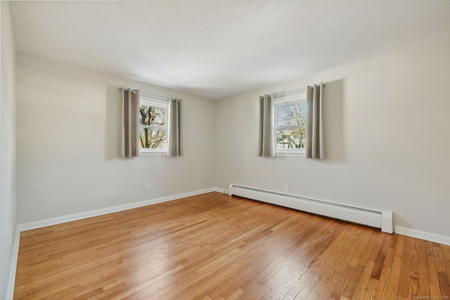 empty room featuring a baseboard radiator and light wood-type flooring