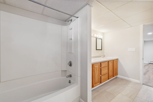 bathroom with shower / bathing tub combination, a baseboard radiator, vanity, tile patterned flooring, and a drop ceiling