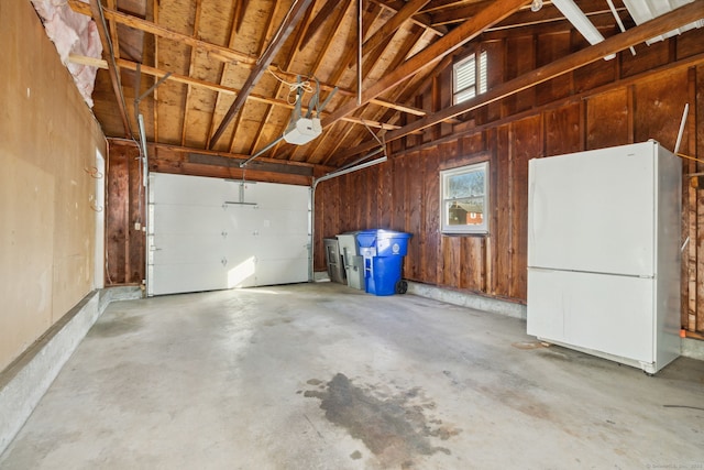 garage featuring a garage door opener and white refrigerator