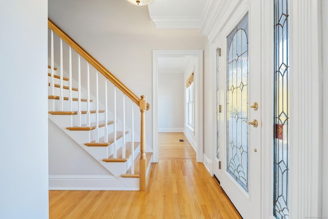 foyer entrance featuring ornamental molding and light wood-type flooring