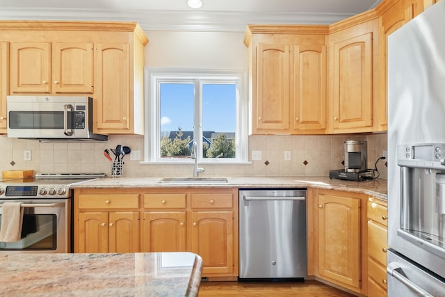 kitchen with sink, ornamental molding, light stone counters, stainless steel appliances, and light brown cabinets