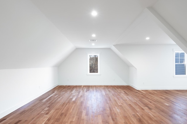 additional living space with lofted ceiling and light hardwood / wood-style flooring