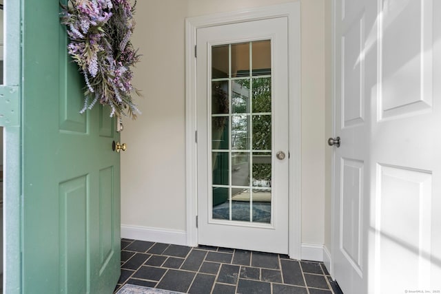 doorway featuring baseboards