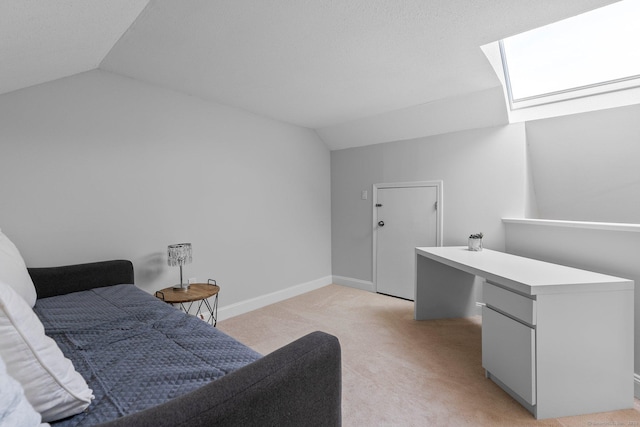 bedroom featuring light carpet, lofted ceiling with skylight, and baseboards