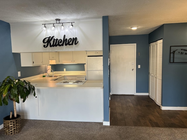 kitchen with sink, white appliances, cream cabinets, and a textured ceiling