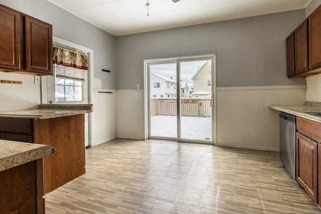 kitchen featuring stainless steel dishwasher and wainscoting