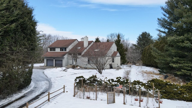 traditional-style home with a garage, a chimney, and fence