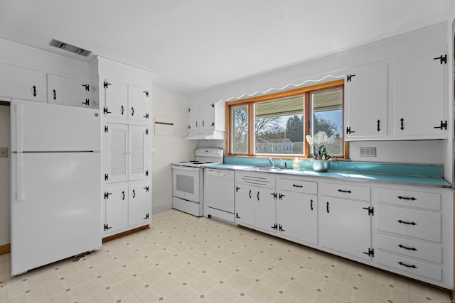 kitchen with light floors, light countertops, white cabinetry, a sink, and white appliances