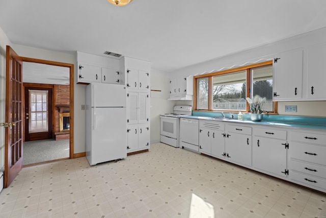 kitchen with white appliances, visible vents, white cabinets, and light floors