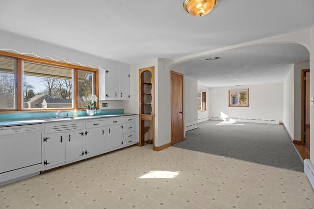 kitchen with visible vents, white cabinets, arched walkways, white dishwasher, and a sink