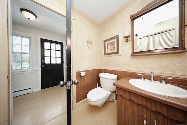 bathroom featuring hardwood / wood-style flooring, vanity, toilet, and a baseboard heating unit