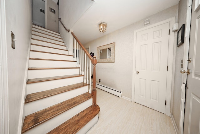 stairs with a baseboard radiator and wood-type flooring