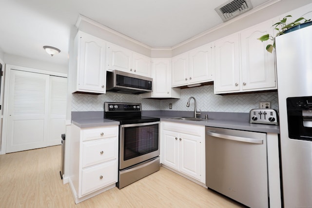 kitchen featuring stainless steel appliances, sink, light hardwood / wood-style flooring, and white cabinets