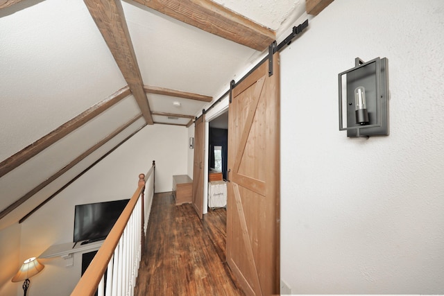 hallway featuring dark hardwood / wood-style floors, a barn door, and beamed ceiling