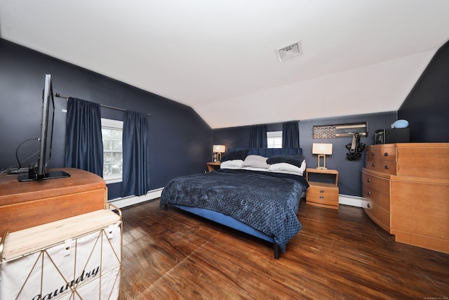 bedroom featuring dark wood-type flooring, lofted ceiling, and a baseboard heating unit