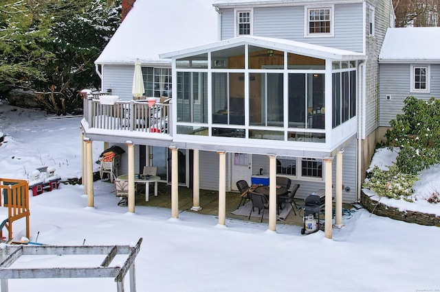 snow covered property featuring a sunroom