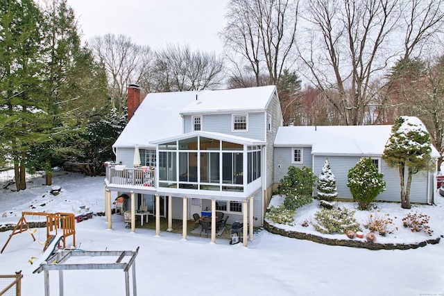 snow covered property with a sunroom