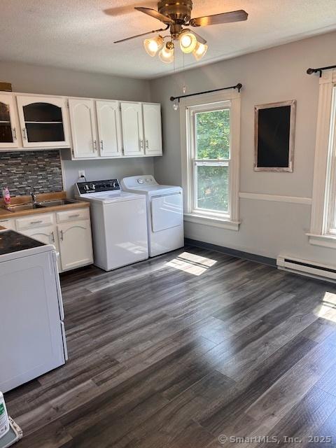 washroom featuring cabinets, washing machine and dryer, sink, and dark wood-type flooring