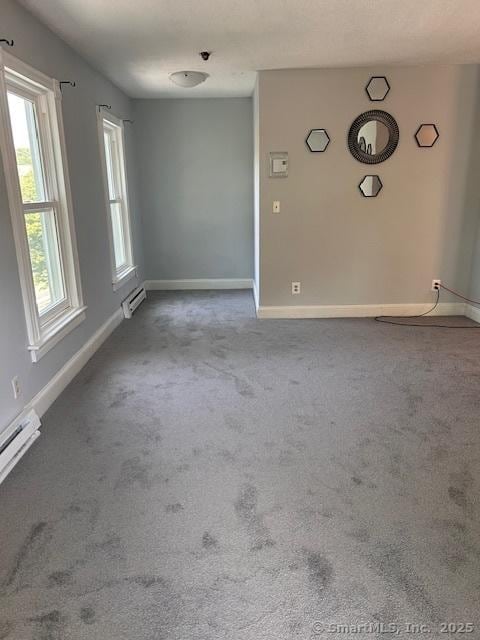 unfurnished room with baseboard heating and carpet flooring