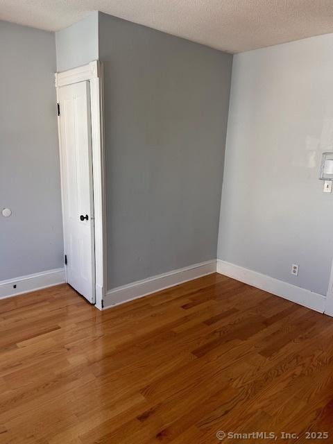 empty room featuring hardwood / wood-style flooring and a textured ceiling