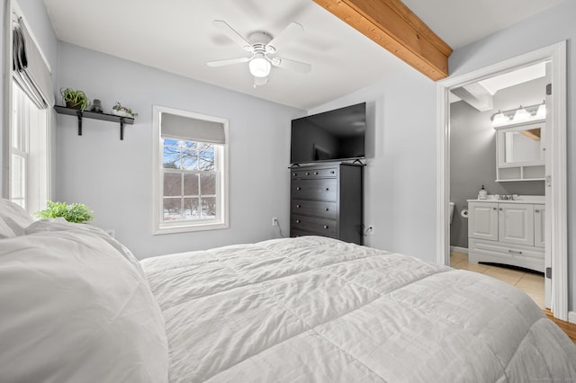 tiled bedroom featuring ceiling fan, ensuite bath, beamed ceiling, and sink