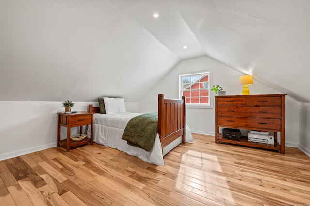 bedroom with light wood-type flooring and lofted ceiling