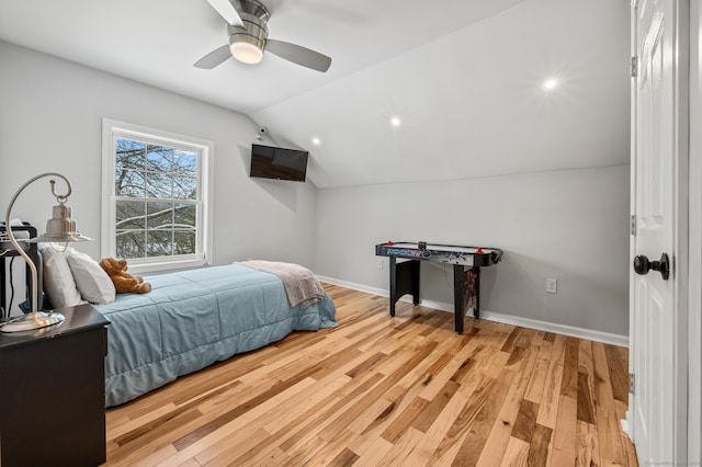 bedroom featuring light wood-type flooring, vaulted ceiling, and ceiling fan