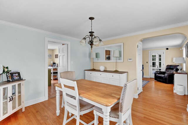 1379 Old N Colony Rd, Meriden, CT 06450 - dining room featuring arched walkways, light wood-style floors, ornamental molding, and a chandelier