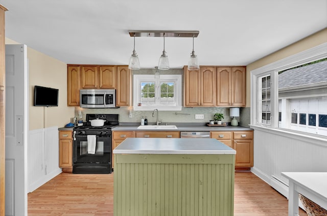 1379 Old N Colony Rd, Meriden, CT 06450 - kitchen with stainless steel appliances, light wood finished floors, a kitchen island, decorative backsplash, and a wainscoted wall