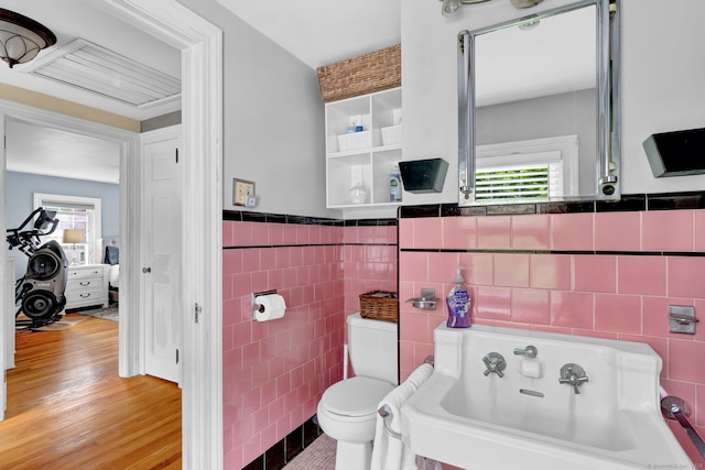 1379 Old N Colony Rd, Meriden, CT 06450 - bathroom with tile walls, a bath, a wainscoted wall, and wood finished floors