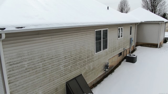 view of snow covered exterior with cooling unit