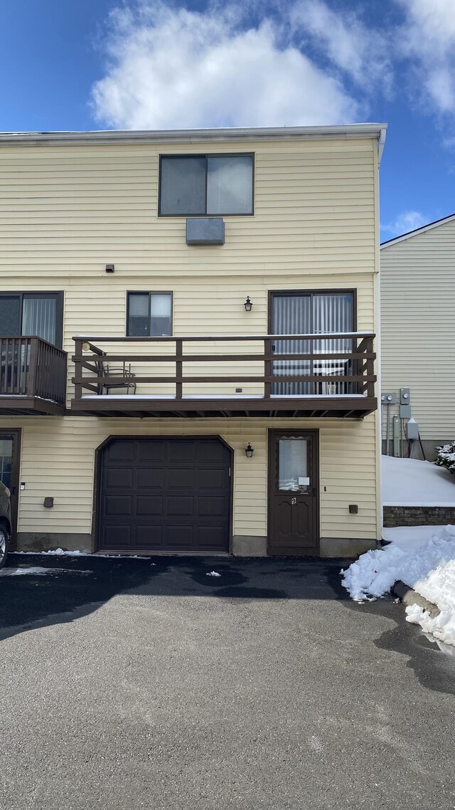 rear view of property featuring a garage and a balcony