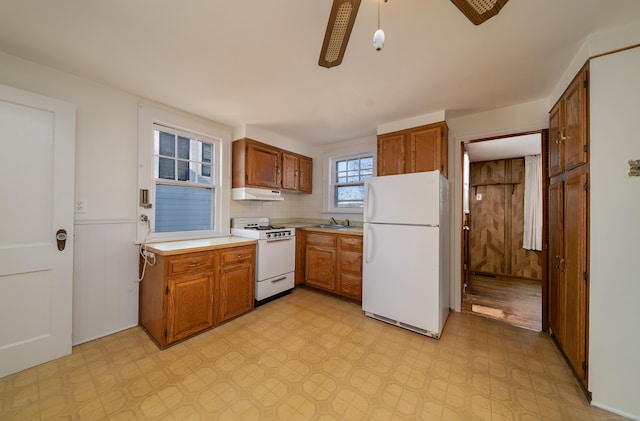 kitchen with tasteful backsplash, ceiling fan, sink, and white appliances