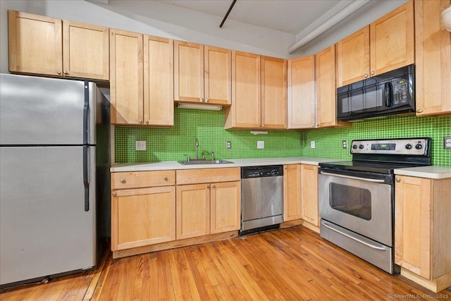 kitchen with tasteful backsplash, appliances with stainless steel finishes, light brown cabinetry, and sink